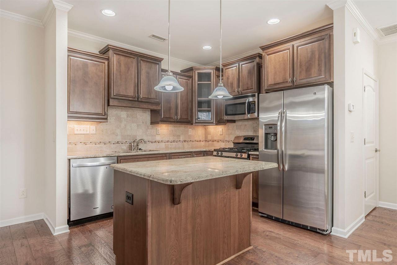 2431 Swans Rest Way Raleigh, NC 27606 - Photo 6 of 25 a kitchen with stainless steel appliances granite countertop a refrigerator a sink and a stove