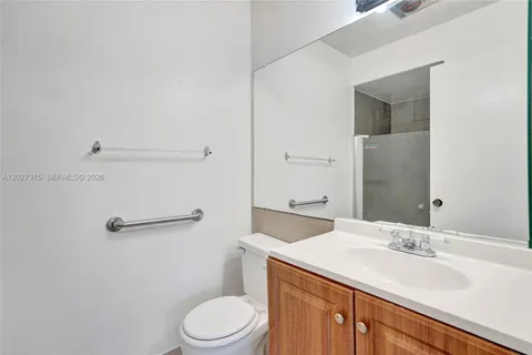 a bathroom with a granite countertop toilet sink and mirror