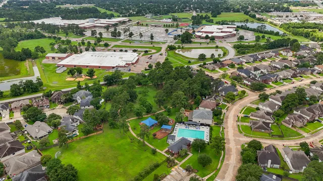 an aerial view of residential houses with outdoor space and parking
