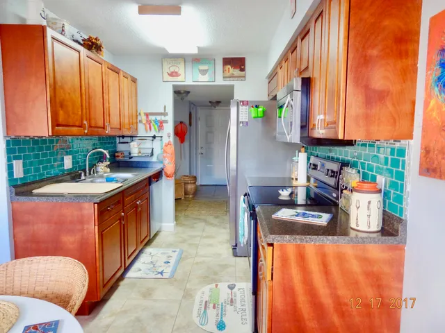 a kitchen with stainless steel appliances granite countertop a sink and a refrigerator