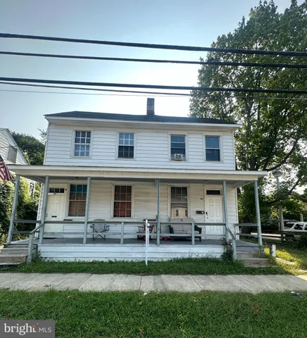 a view of house with a big yard and a large tree