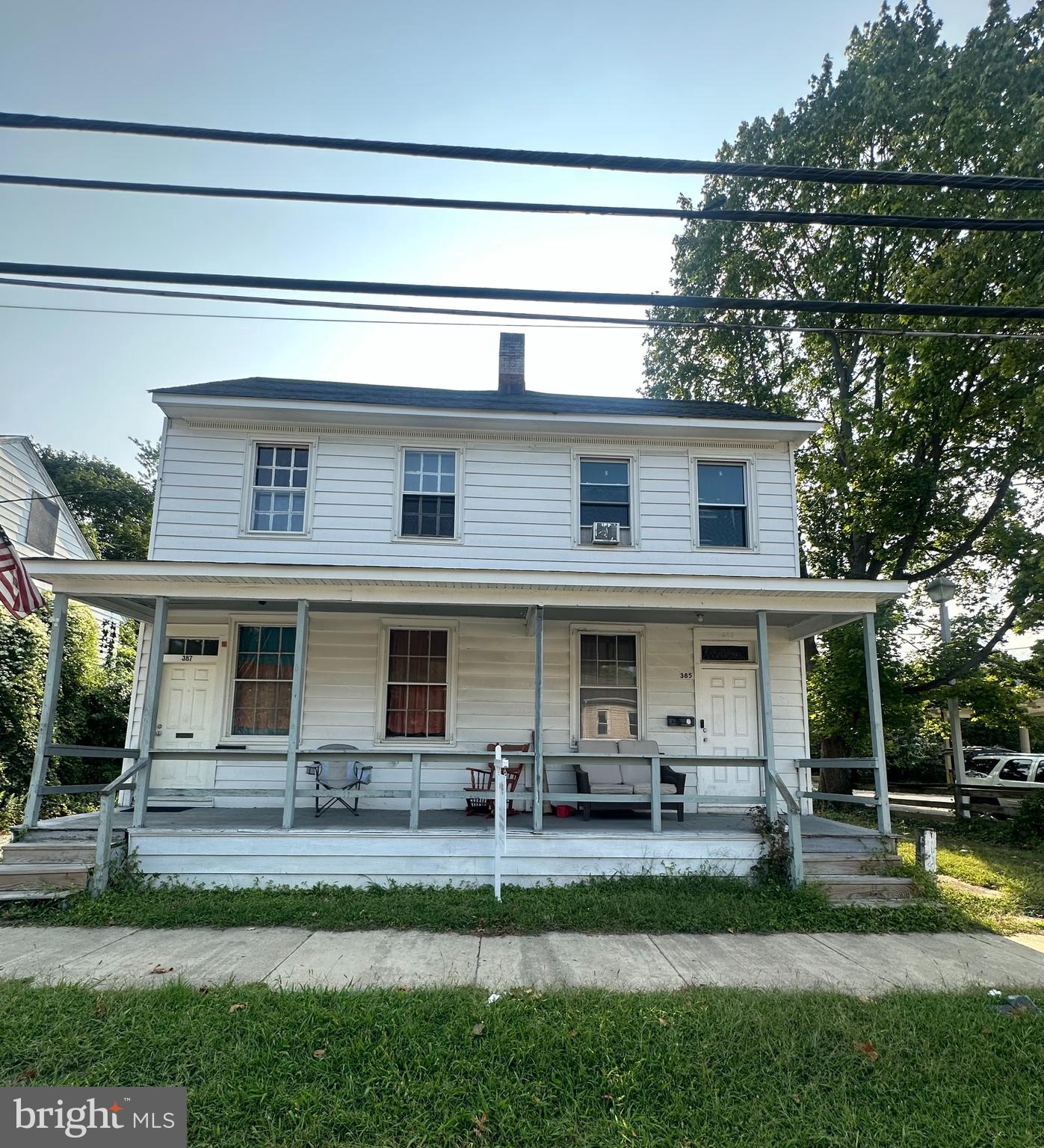 a view of house with a big yard and a large tree