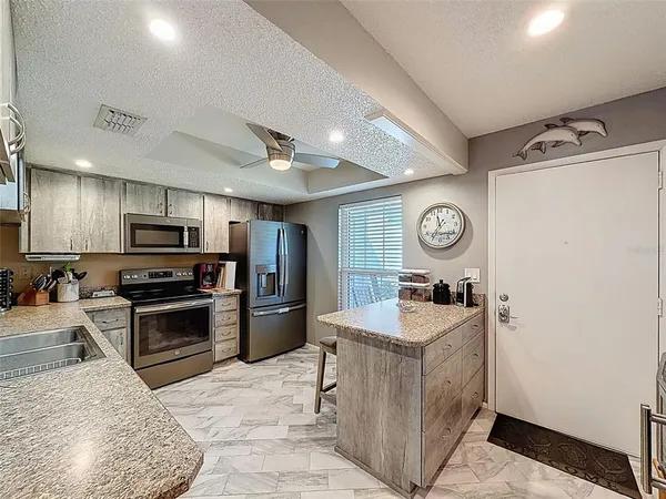 a kitchen with stainless steel appliances granite countertop sink stove refrigerator and cabinets