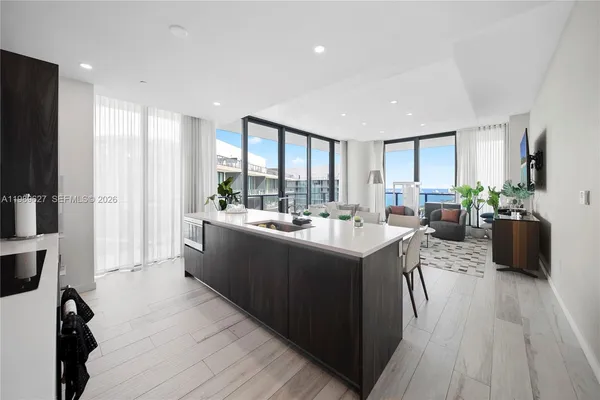 a kitchen with a sink a counter top space a large window and stainless steel appliances