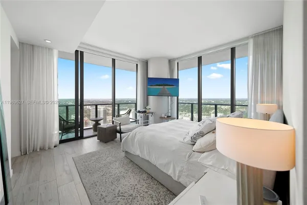 a spacious bedroom with a large bed and a large window