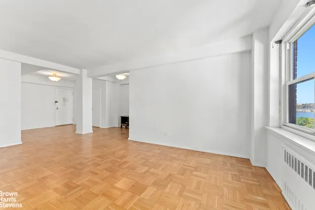 a view of empty room with wooden floor