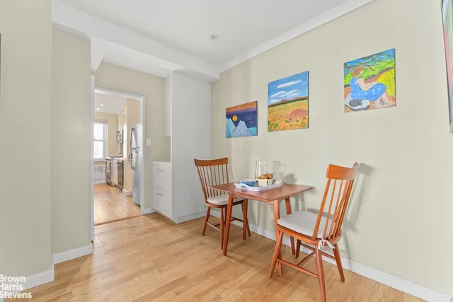 a bedroom with a bed a desk and chair with the wooden floor