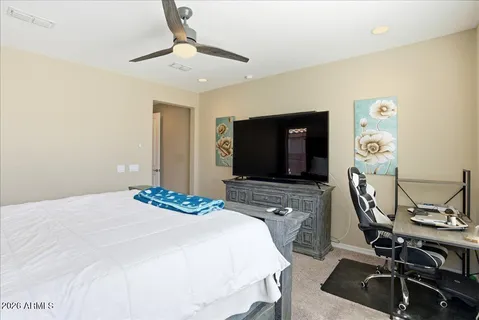 a bedroom with a bed chair and a large window