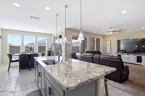 a kitchen with stainless steel appliances kitchen island granite countertop a sink and a refrigerator