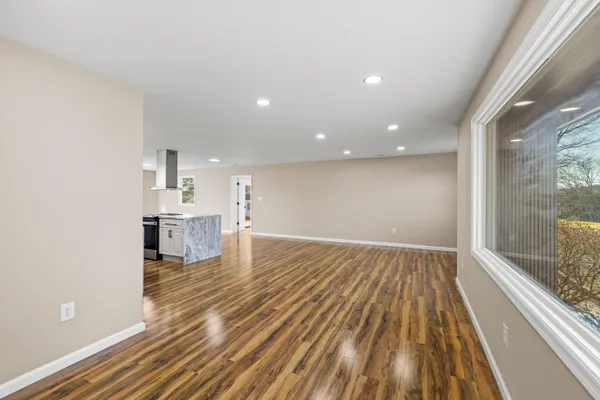 a living room with kitchen view and a refrigerator
