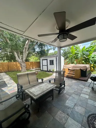 a living room with patio furniture and a floor to ceiling window