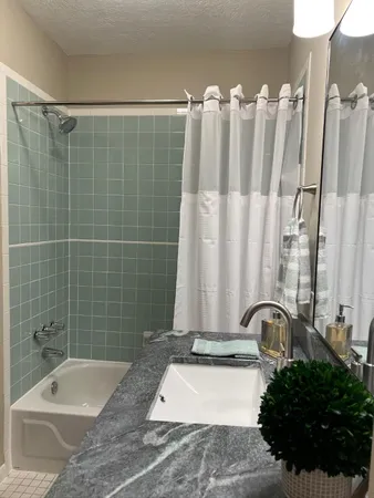 a bathroom with a bathtub a sink and a shower