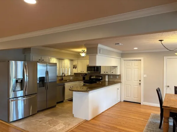 a kitchen with stainless steel appliances kitchen island granite countertop a refrigerator and a stove top oven