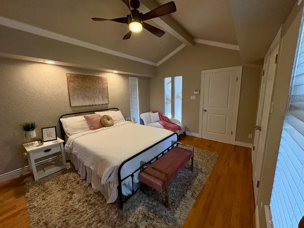 a spacious bedroom with a bed and a chandelier