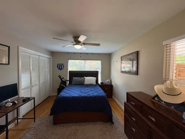 a bedroom with a bed and a dresser next to a window