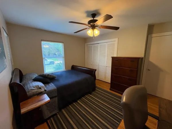 a bedroom with a bed and wooden floor