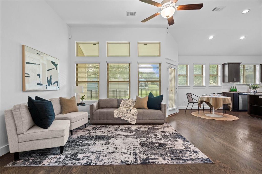 1765 Rowdy Loop, Unit 47 Leander, TX 78641 - Photo 10 of 40 Rich hardwood flooring anchors the airy, open-concept living space framed by a wall of windows.