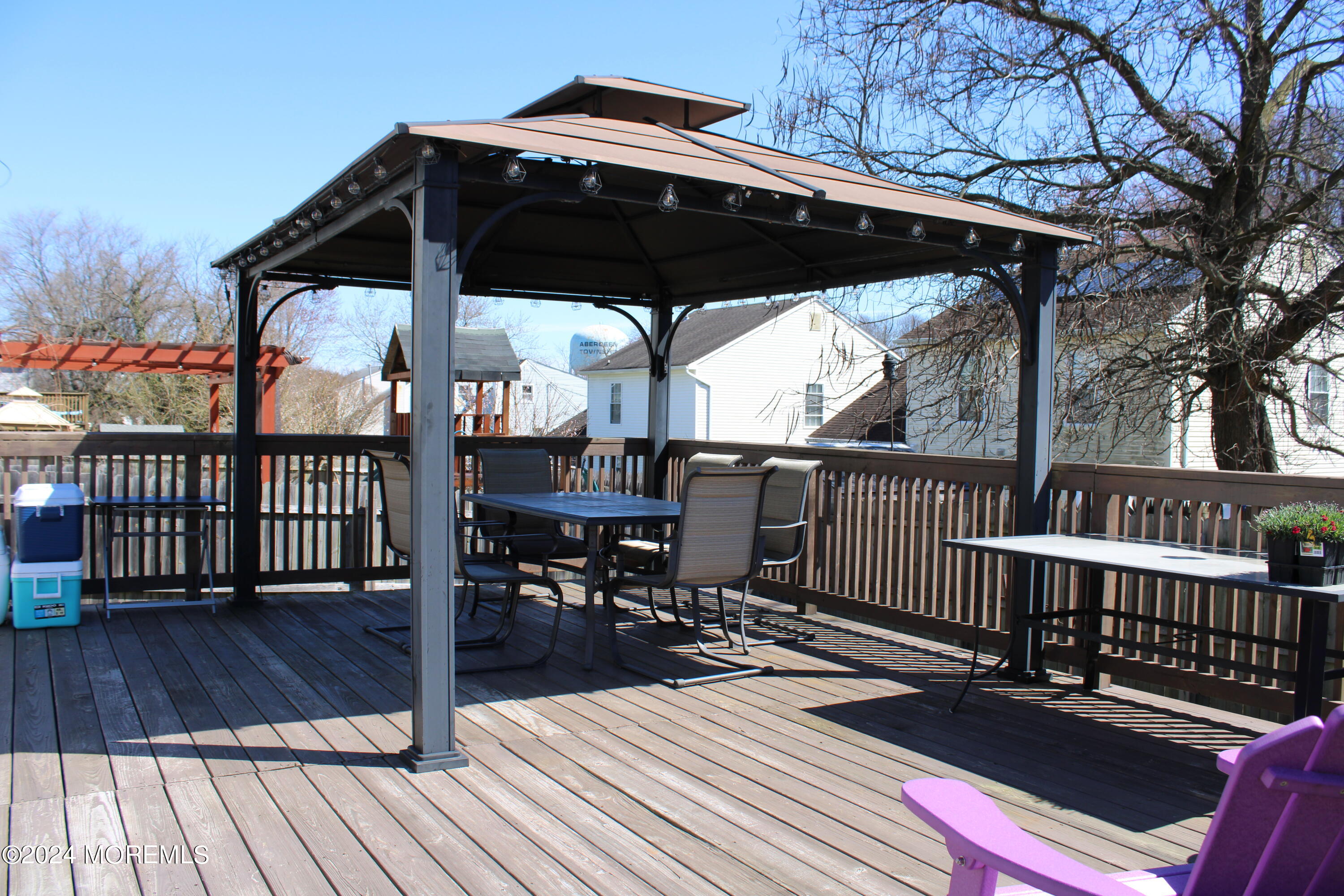 97 County Road Cliffwood, NJ 07721 - Photo 4 of 24 a view of a roof deck with table and chairs under an umbrella with wooden floor