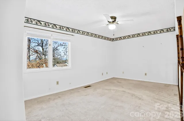 a picture of a bathroom with a white wall and a potted plant