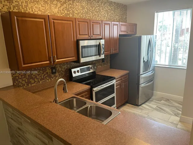 a kitchen with stainless steel appliances a refrigerator sink and cabinets