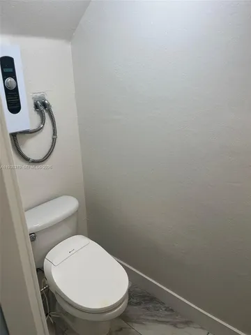 a white toilet sitting next to a shower
