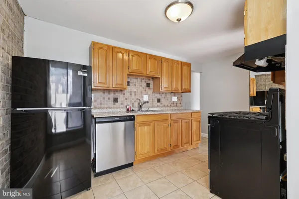 a kitchen with granite countertop a refrigerator stove top oven and sink