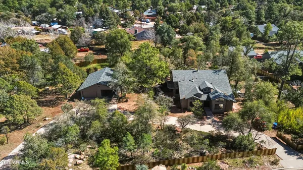 an aerial view of residential house with outdoor space and trees all around
