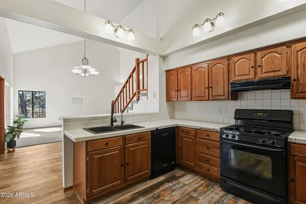 a kitchen with granite countertop a refrigerator and a stove top oven