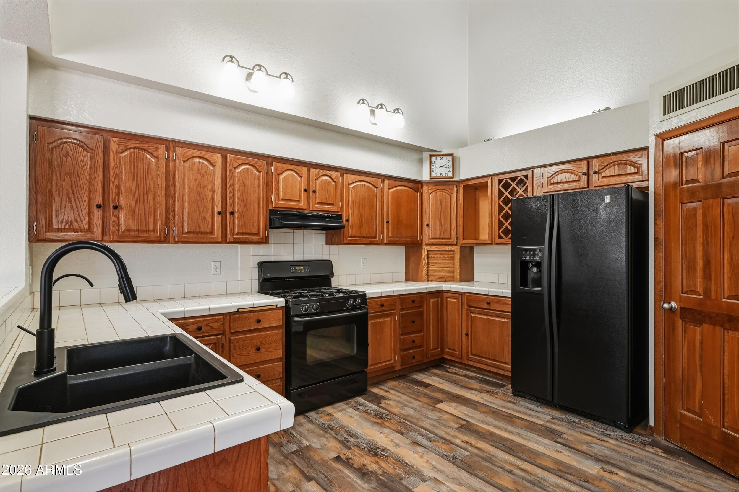 1101 North McLane Road Payson, AZ 85541 - Photo 14 of 65 a kitchen with granite countertop a refrigerator and a stove top oven