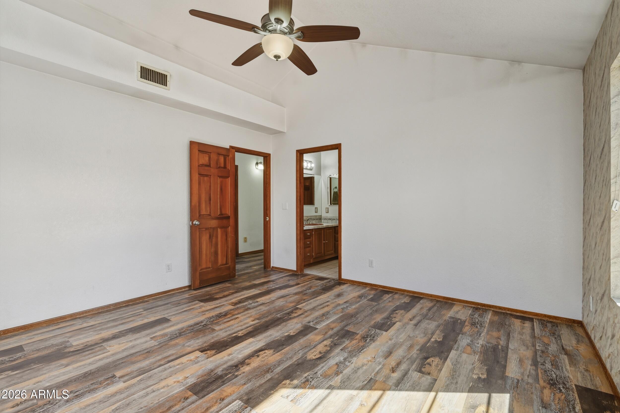 1101 North McLane Road Payson, AZ 85541 - Photo 18 of 65 a view of an empty room with wooden floor and a ceiling fan