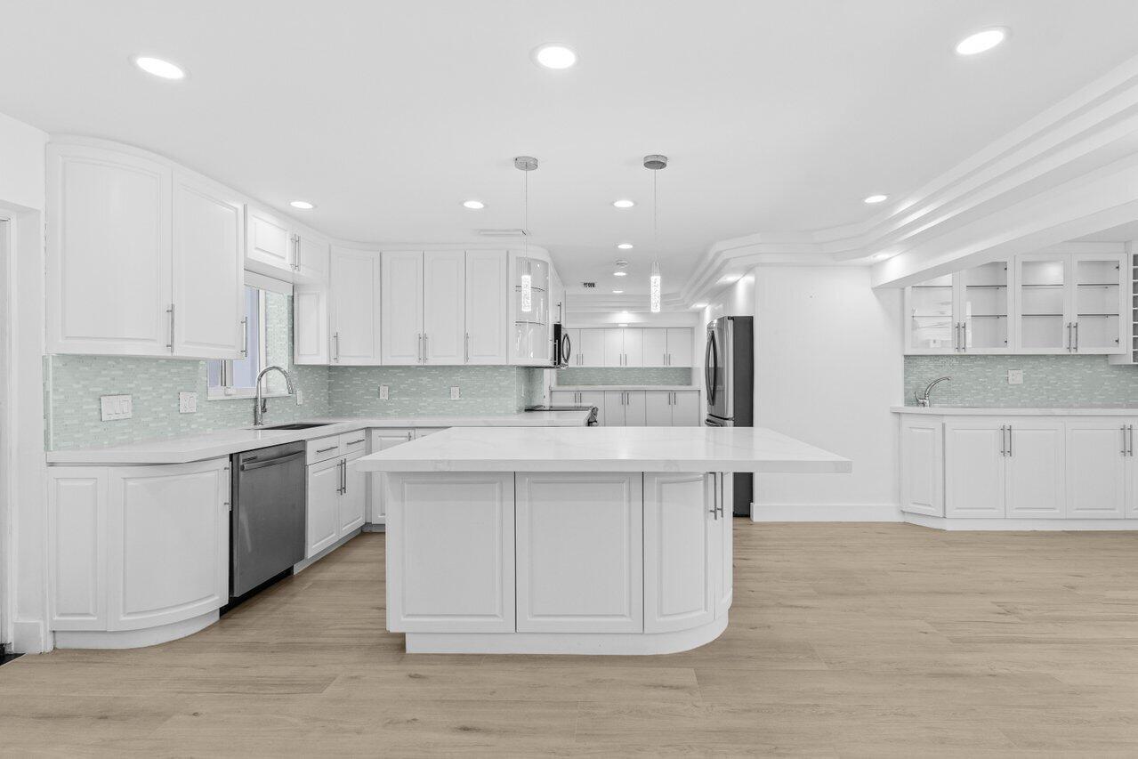 2611 Northeast 49th Street Lighthouse Point, FL 33064 - Photo 11 of 56 a kitchen with stainless steel appliances granite countertop a sink a stove a refrigerator and white cabinets