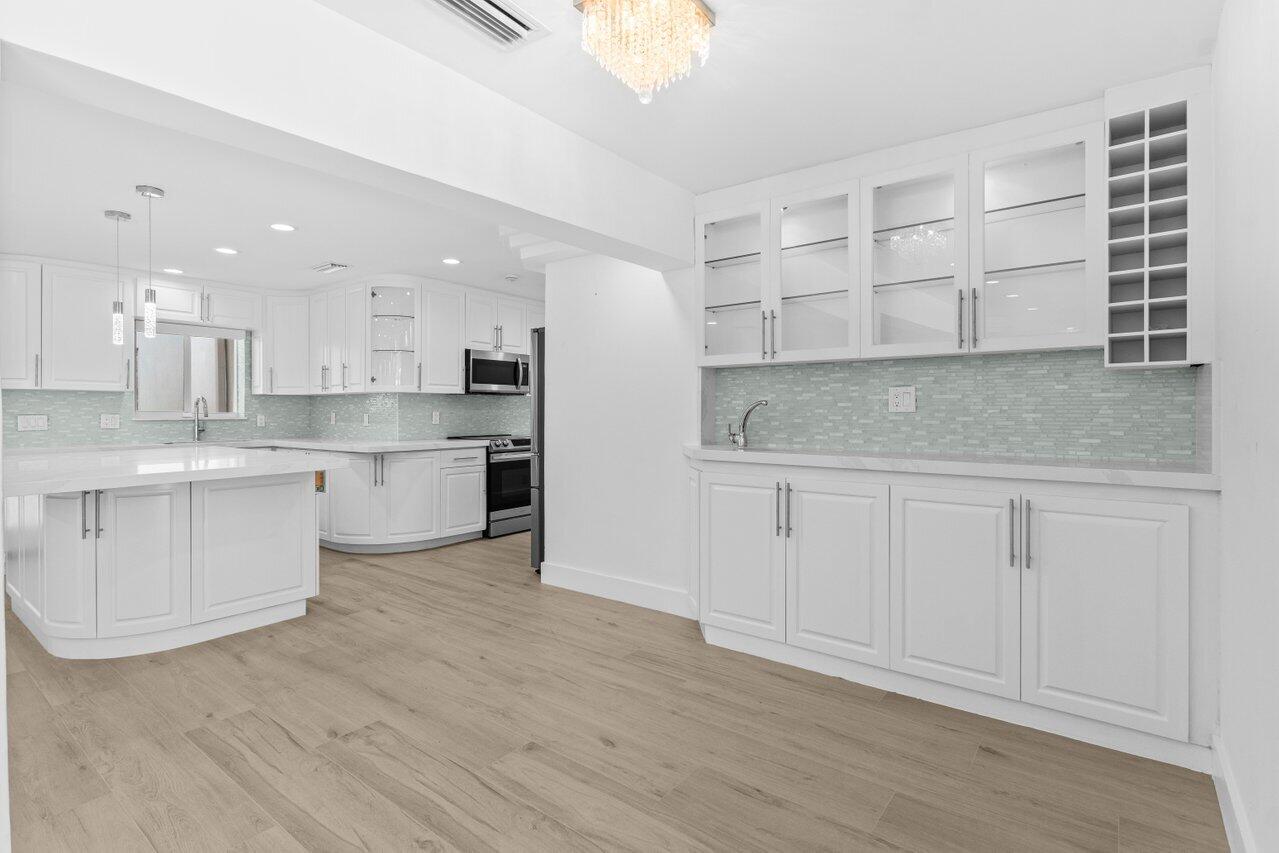 2611 Northeast 49th Street Lighthouse Point, FL 33064 - Photo 12 of 56 a kitchen with white cabinets and white appliances