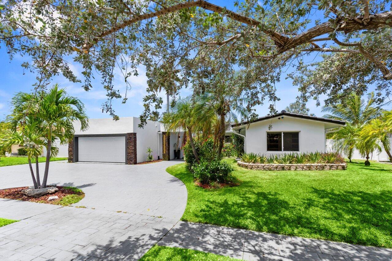 2611 Northeast 49th Street Lighthouse Point, FL 33064 - Photo 2 of 56 a front view of a house with garden