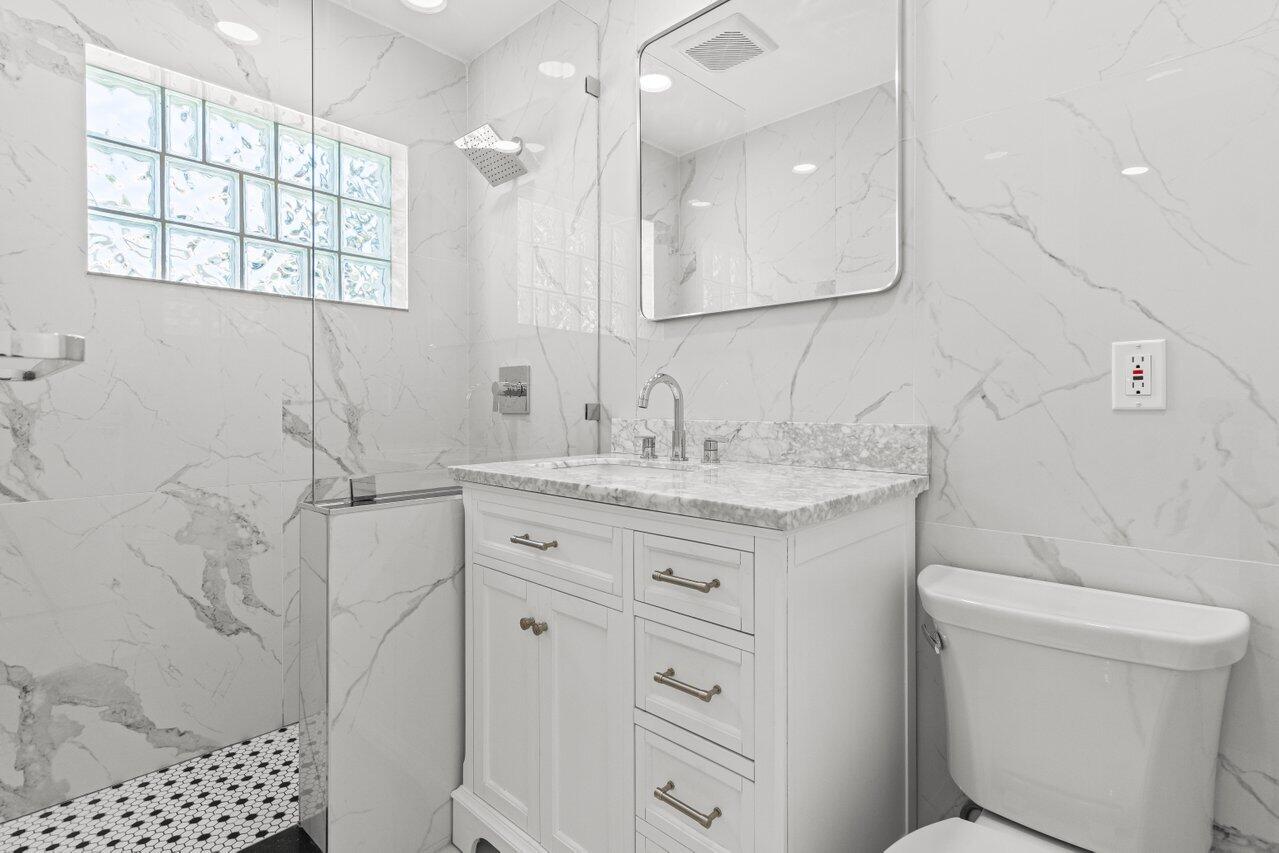 2611 Northeast 49th Street Lighthouse Point, FL 33064 - Photo 24 of 56 a bathroom with a granite countertop sink toilet and shower