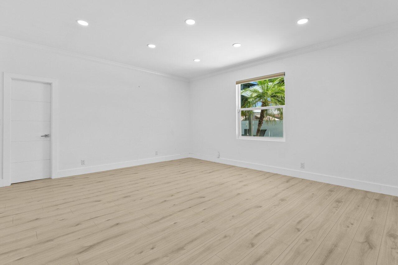 2611 Northeast 49th Street Lighthouse Point, FL 33064 - Photo 27 of 56 an empty room with wooden floor and windows