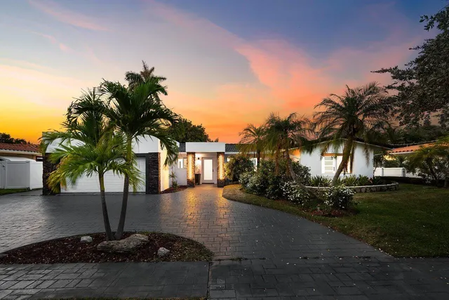 a vase of flowers sitting on a floor in front of house