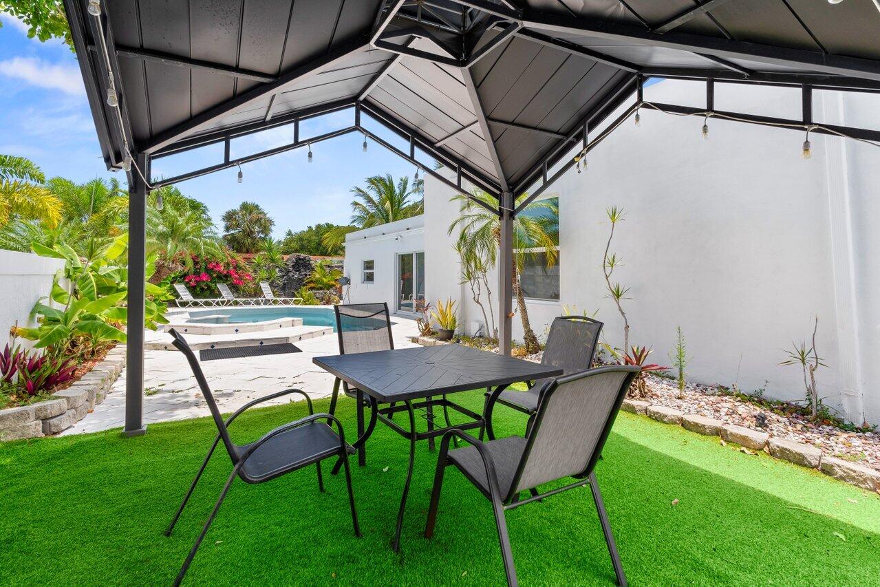 2611 Northeast 49th Street Lighthouse Point, FL 33064 - Photo 38 of 56 a patio with table and chairs and potted plants