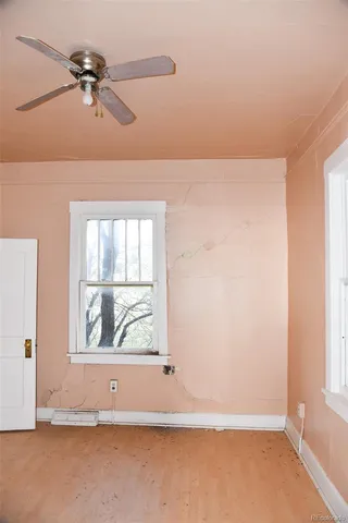 an empty room with fan and windows