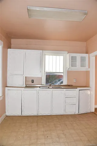 a kitchen with white cabinets and white appliances