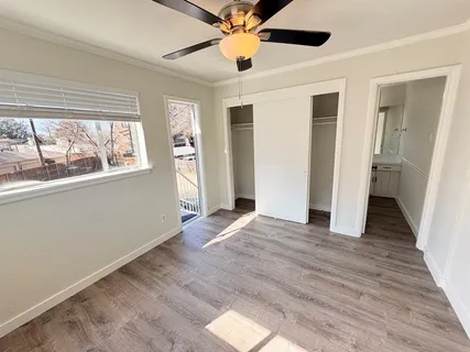 a view of a big room with wooden floor and windows