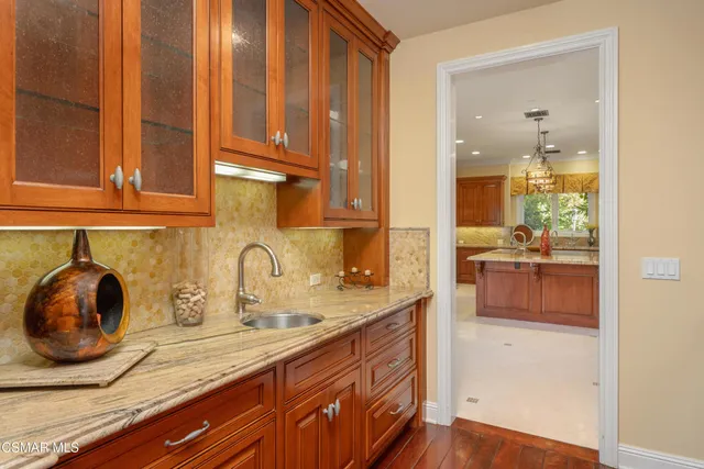 a kitchen with stainless steel appliances granite countertop a stove a sink and a wooden floors