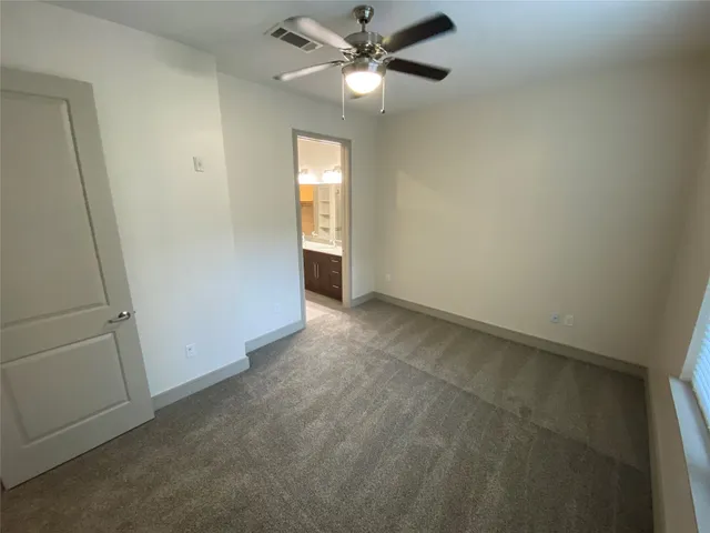 an empty room with closet and windows