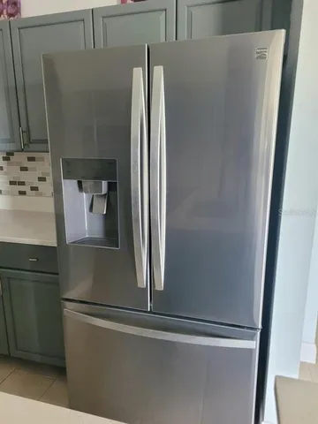 a view of an empty room with a chandelier fan