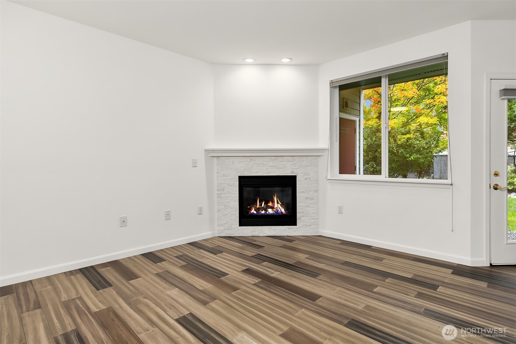 13000 Admiralty Way, Unit L104 Everett, WA 98204 - Photo 4 of 21 a view of an empty room with wooden floor and a window