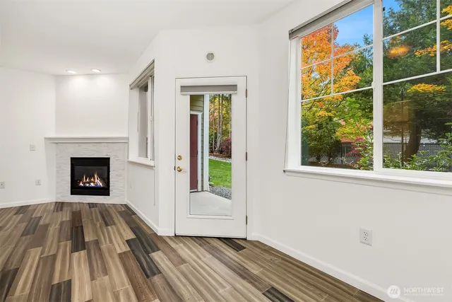 a view of a livingroom with wooden floor and a fireplace