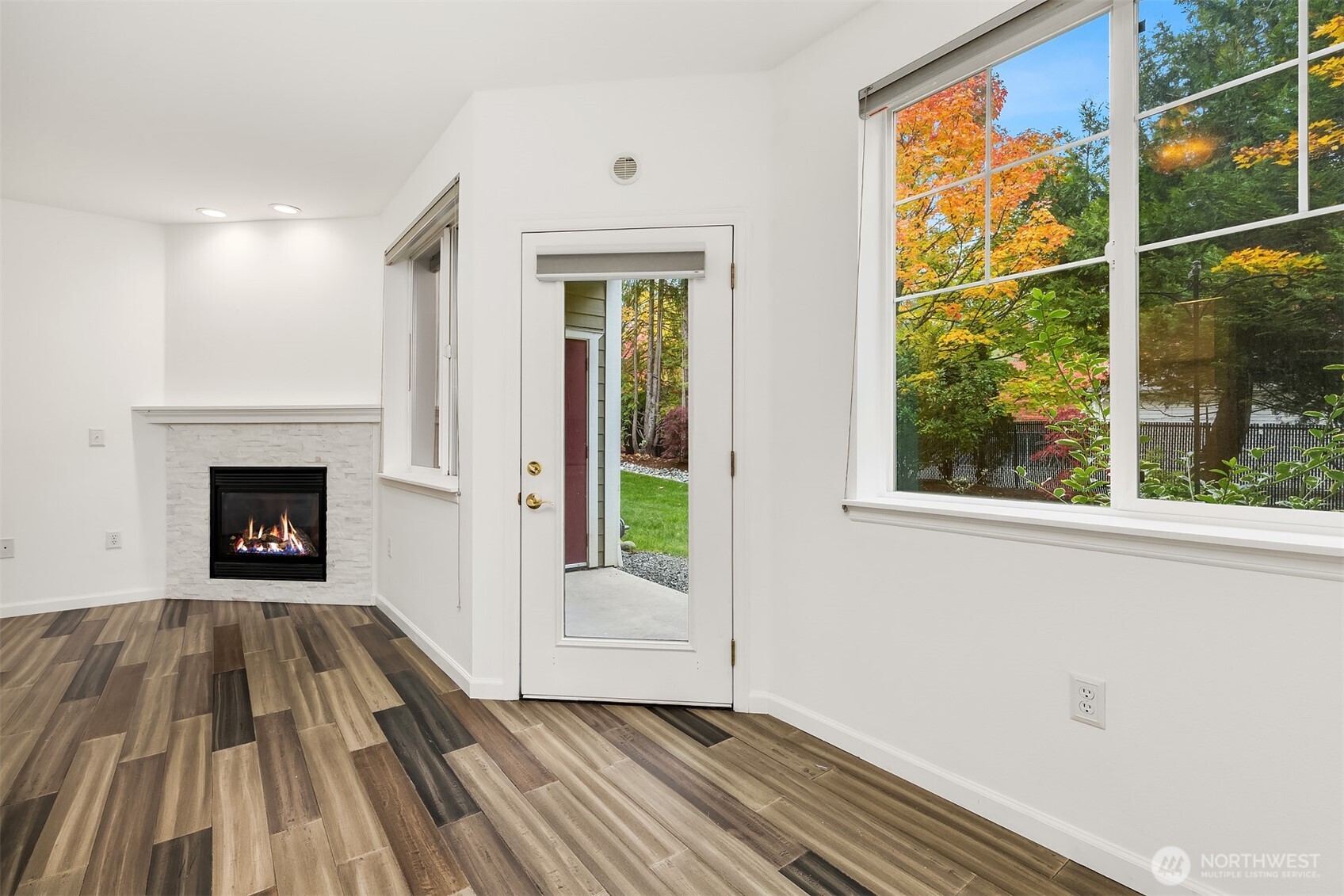 13000 Admiralty Way, Unit L104 Everett, WA 98204 - Photo 7 of 21 a view of a livingroom with wooden floor and a fireplace