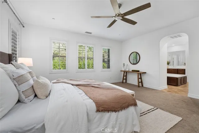 a spacious bedroom with a bed and a chandelier