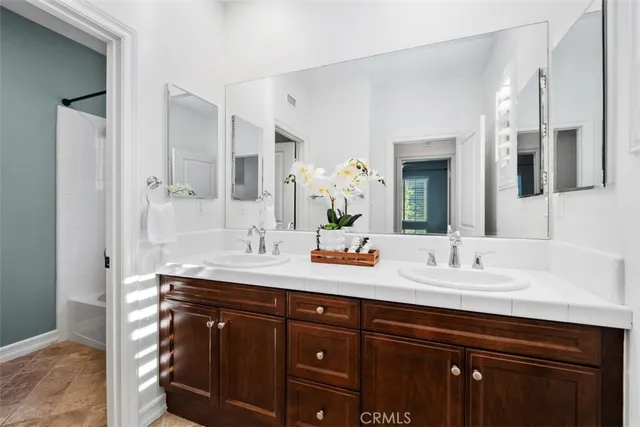 a bathroom with a granite countertop sink double and mirror