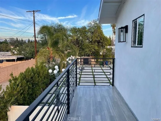 a view of a balcony with wooden floor and potted plants