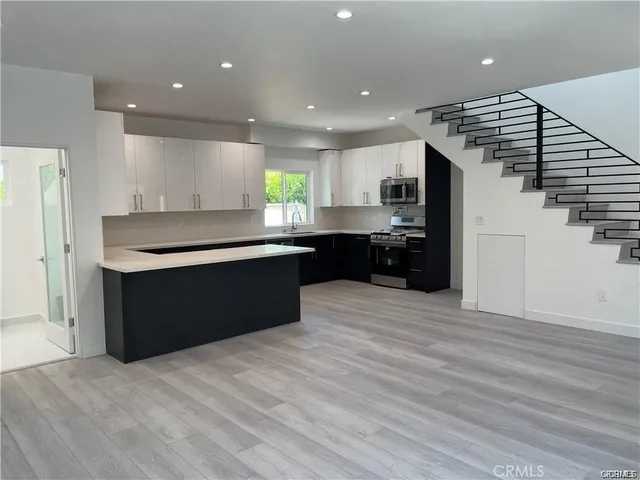 a kitchen with stainless steel appliances granite countertop a refrigerator and a sink
